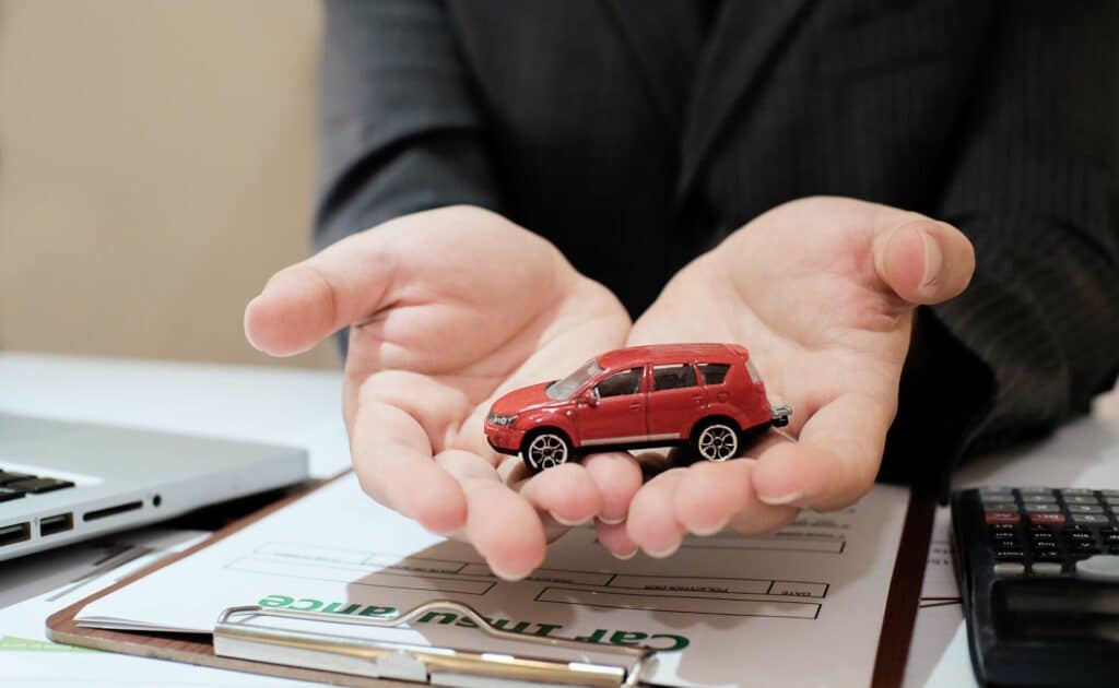 a red toy car on the hands